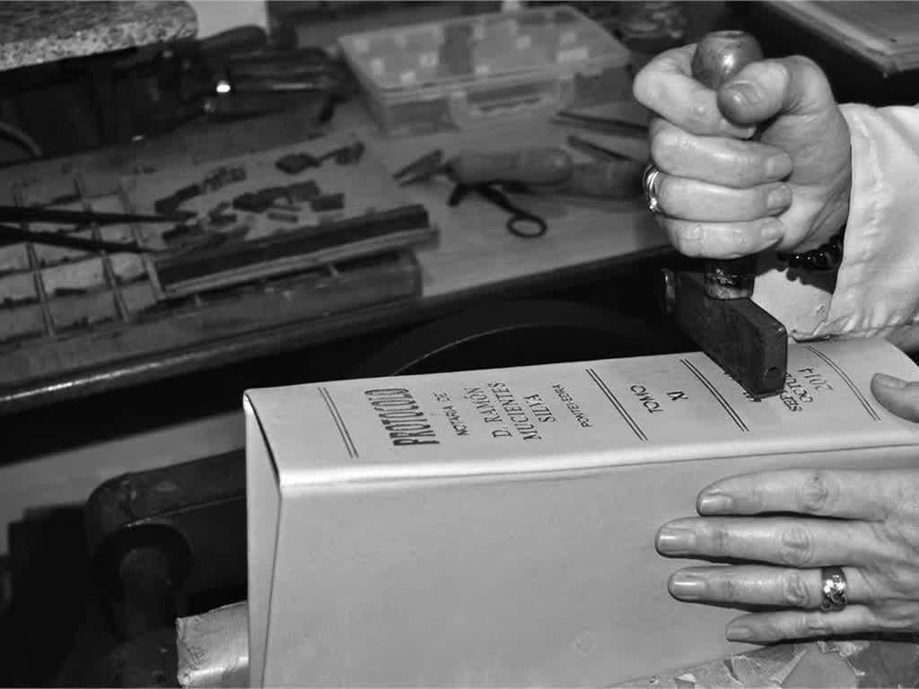 Restauración artesanal del lomo de un libro antiguo en el taller de Vigoarte en Vigo